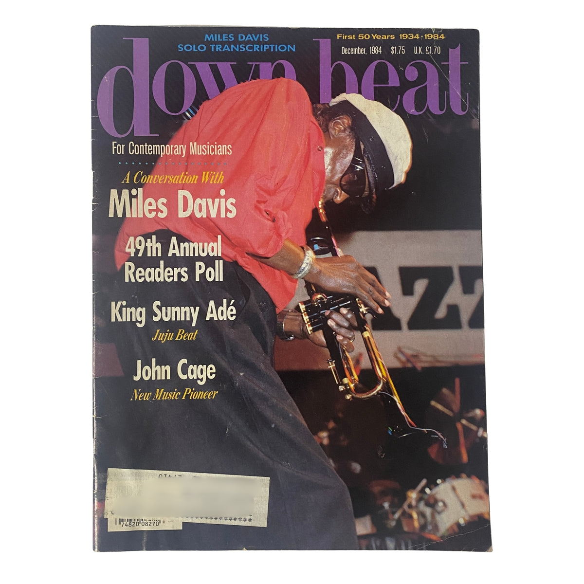 Down Beat Magazine December 1984 featuring Miles Davis on the cover, showcasing highlights from the 49th Annual Readers Poll, King Sunny Adé, and John Cage.