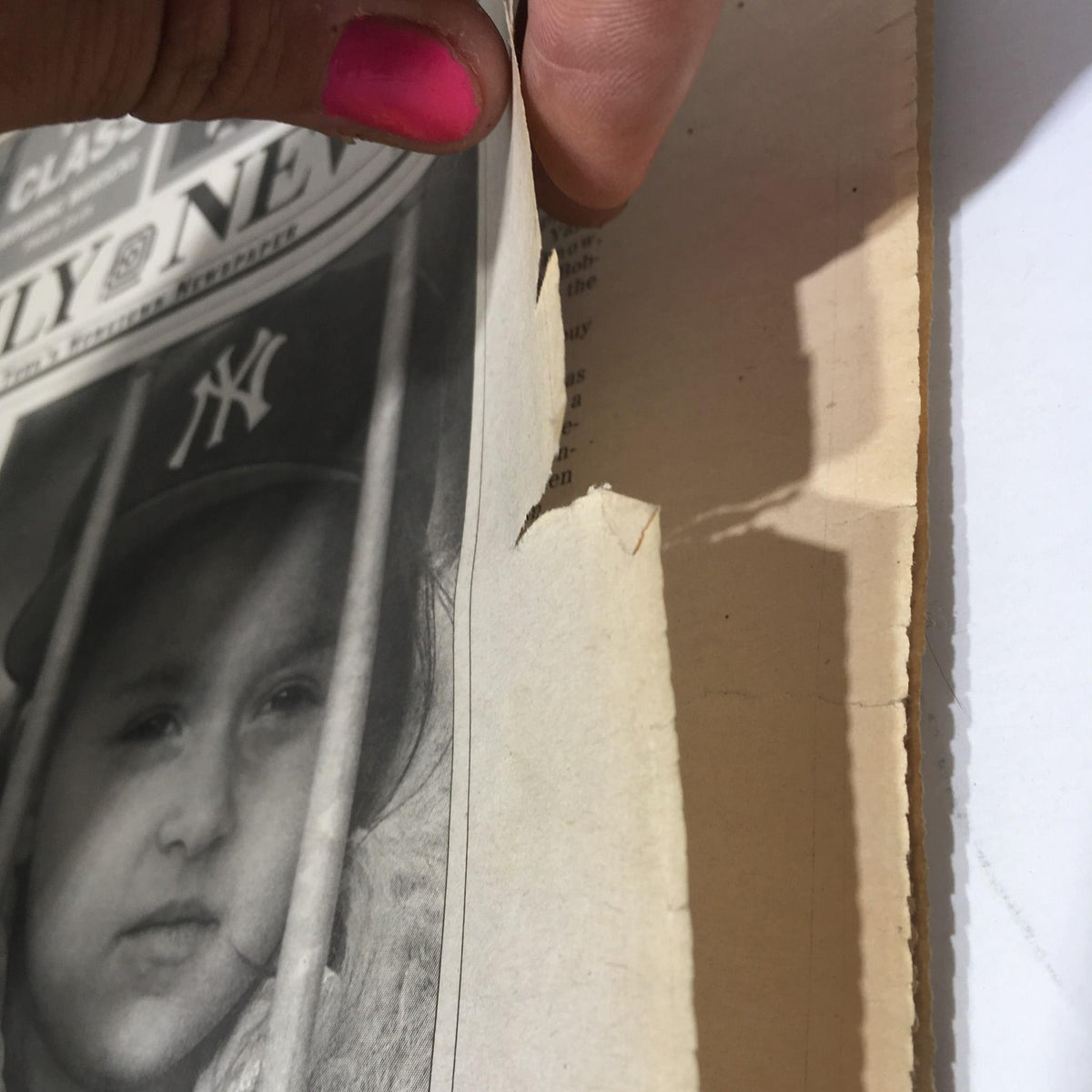 Close-up view of the edge of a New York Daily News newspaper from October 27, 1996, featuring a tear, illustrating wear while highlighting the classic design of the publication 'Goin' For Glory.'