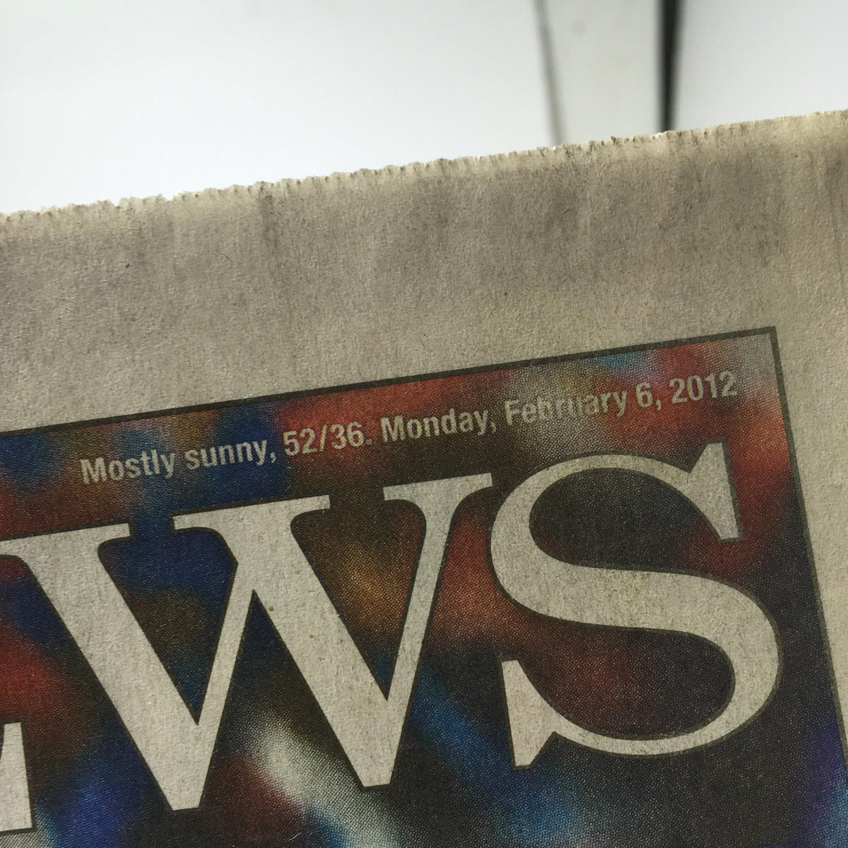 Close-up of the New York Daily News February 6, 2012, showing the date and weather forecast, adding context to the historical moment of Eli Manning's Super Bowl win.