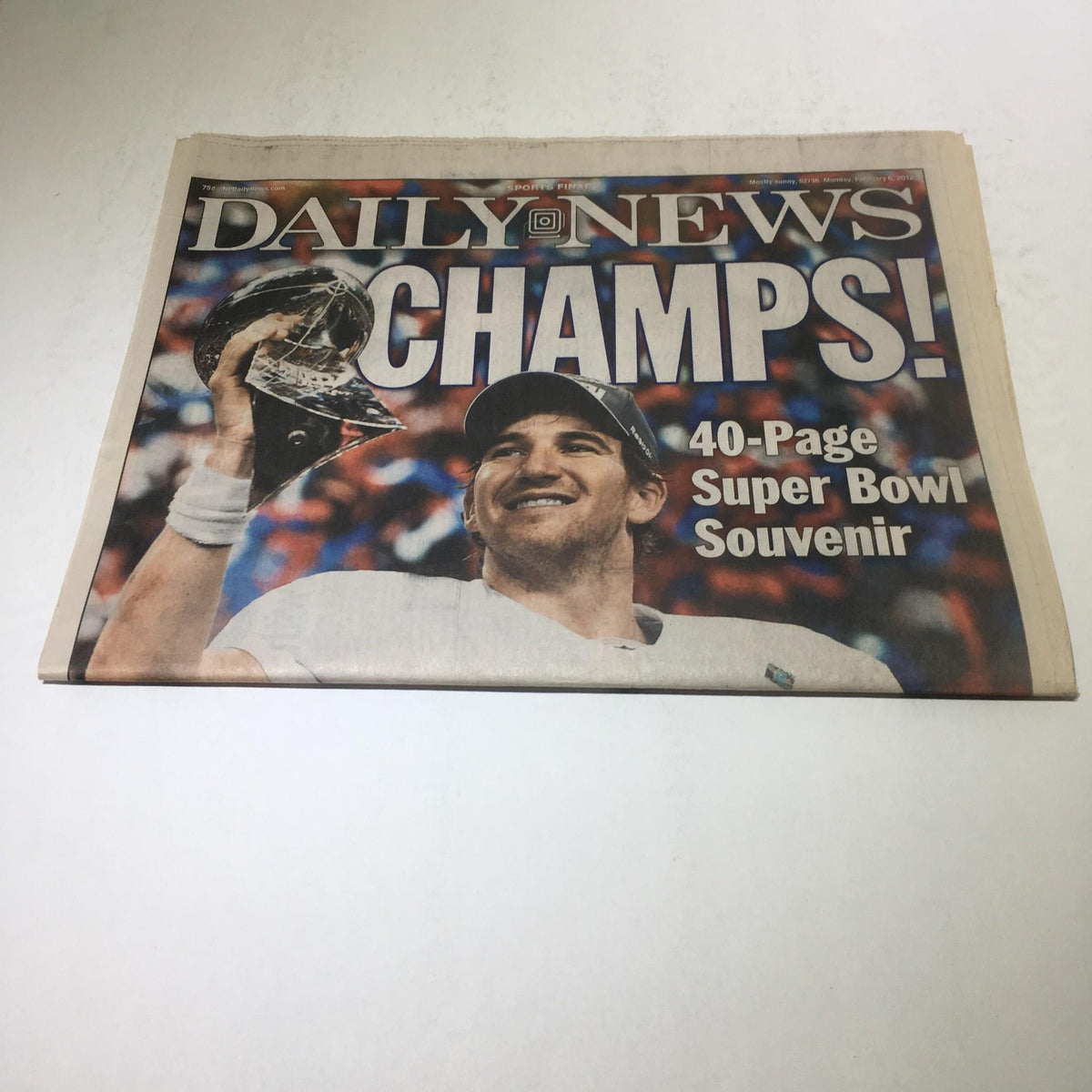 Another view of the New York Daily News February 6, 2012, highlighting Eli Manning holding the Super Bowl trophy, celebrating the NY Giants' championship achievement.