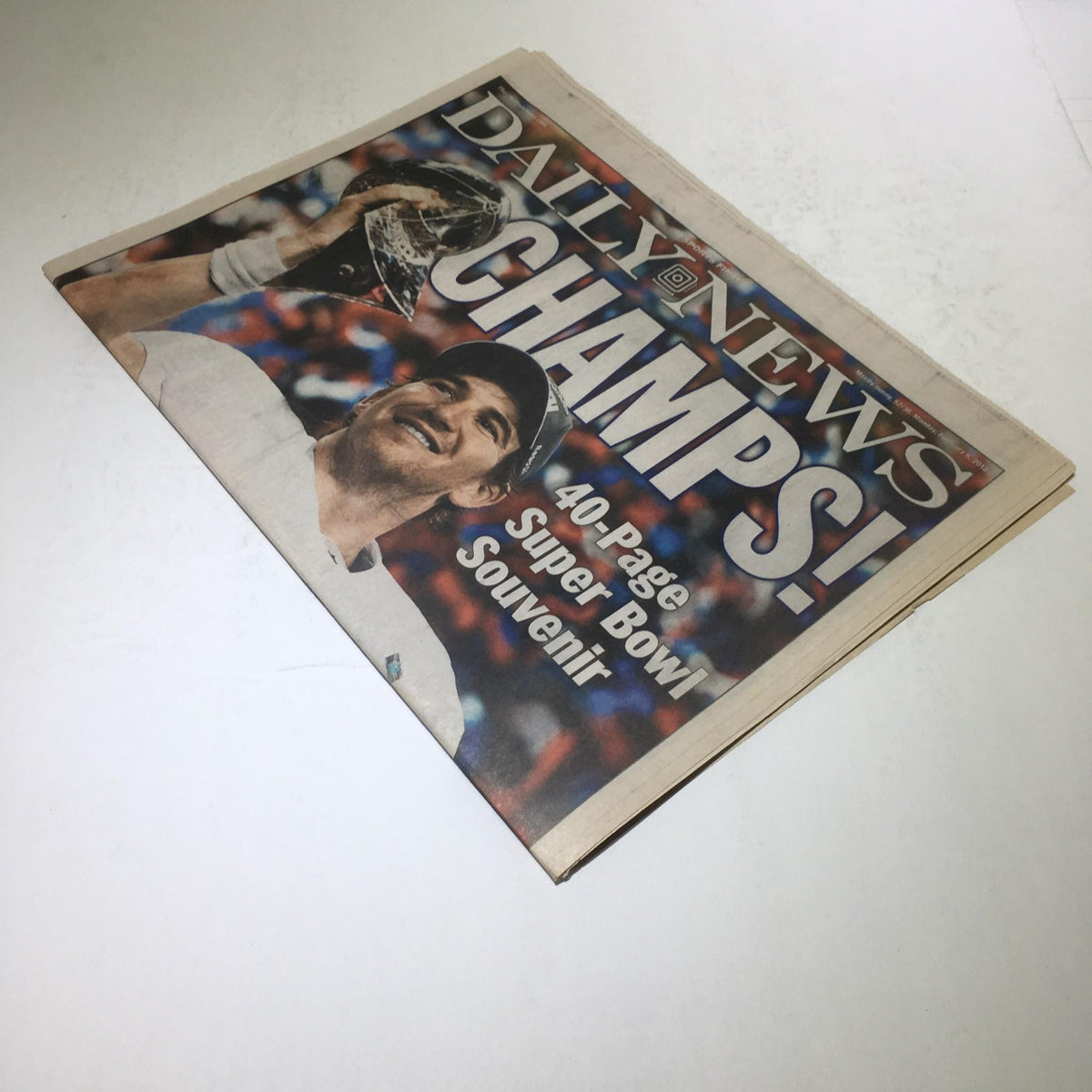Cover of New York Daily News celebrating Super Bowl Champions with Eli Manning holding the trophy, labeled 'DAILY NEWS CHAMPS!!' and showcasing a 40-page Super Bowl souvenir from February 6, 2012.