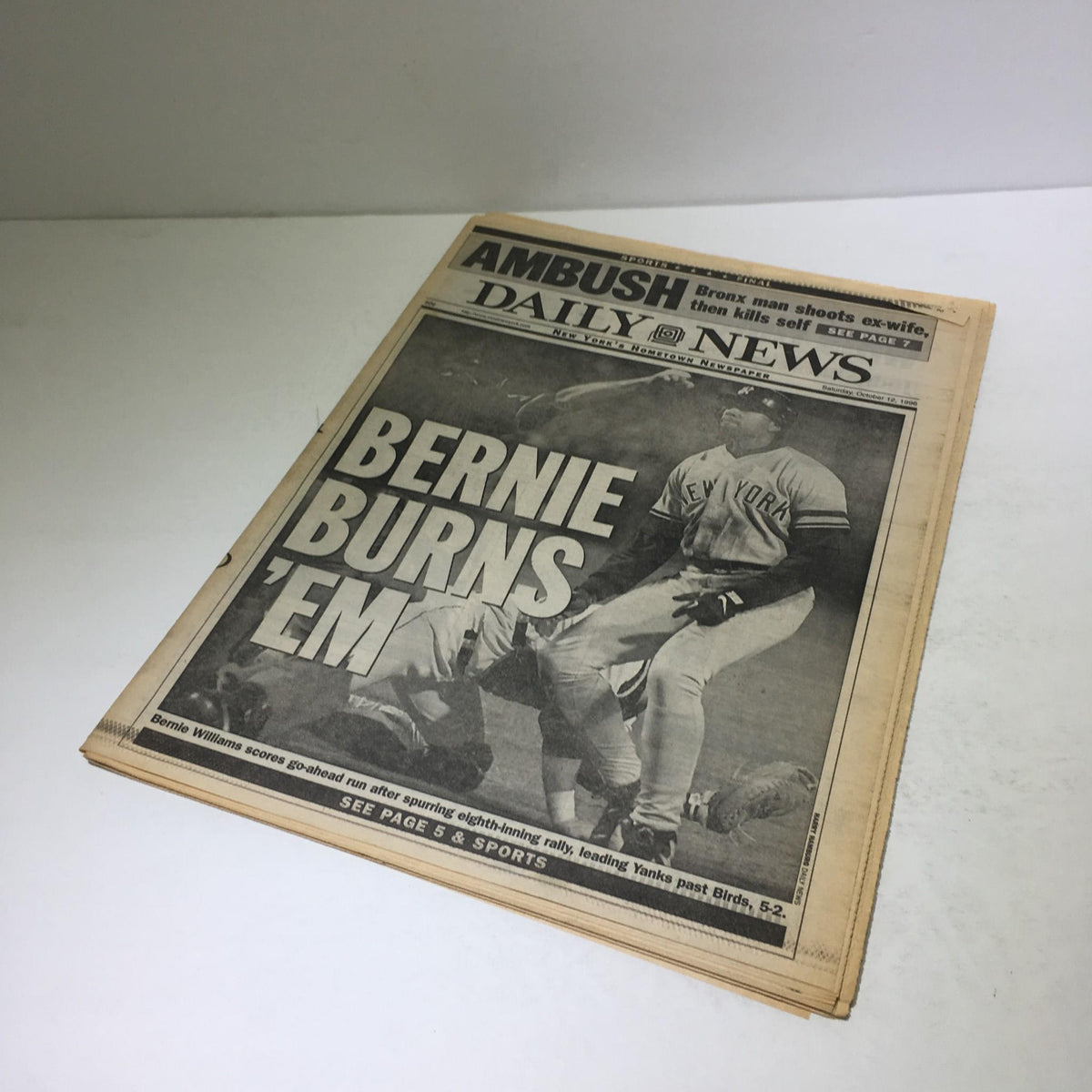 An angled view of the front page of New York Daily News from October 12, 1996, featuring the headline 'Bernie Burns 'Em', emphasizing the significance of the Yankees game.