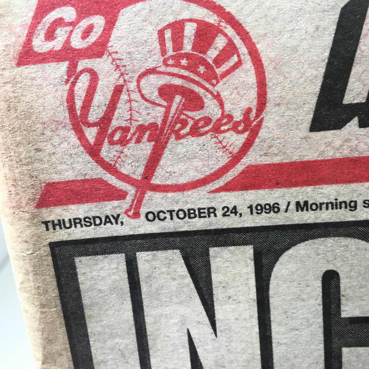 Close-up of the New York Post newspaper dated October 24, 1996, showcasing the 'Go Yankees!' graphic along with the date, highlighting its significance in baseball history.