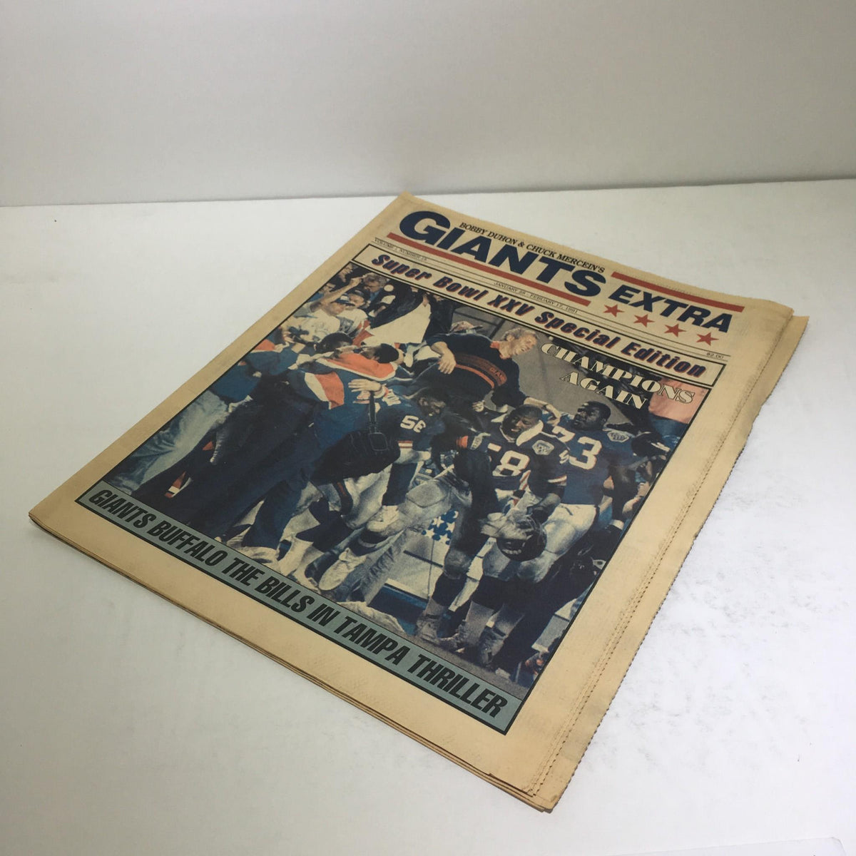 Front view of the Giants Extra newspaper celebrating the New York Giants' Super Bowl XXV victory, dated February 17, 1991, with a bold headline 'Champions Again'.