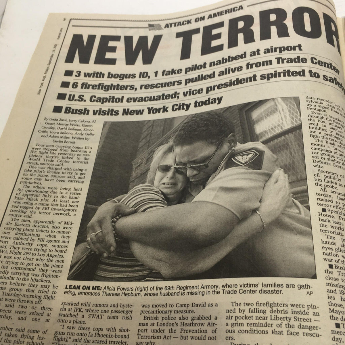 Headline page of the New York Post titled 'New Terror,' featuring a touching photograph of a woman embracing a firefighter amidst the aftermath of the September 11 attacks.