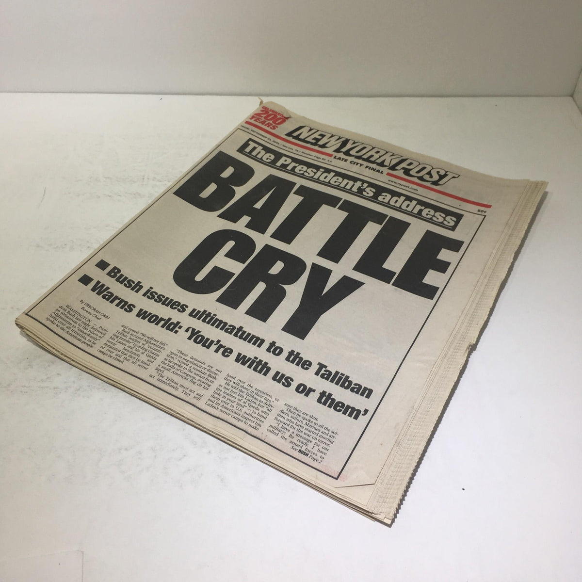 New York Post cover showing the headline 'Battle Cry' related to President Bush's statement post-9/11, emphasizing the urgent message to the Taliban. The edition reflects on the significant historical context of the statement.