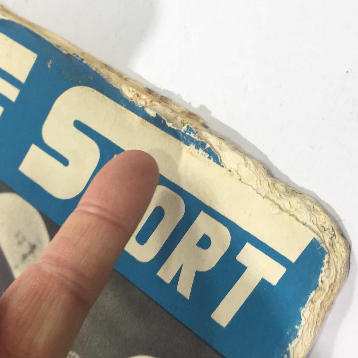 Close-up of the wear and tear on the top edge of the VTG Cycle Sport Magazine December 1962, showcasing its vintage condition.
