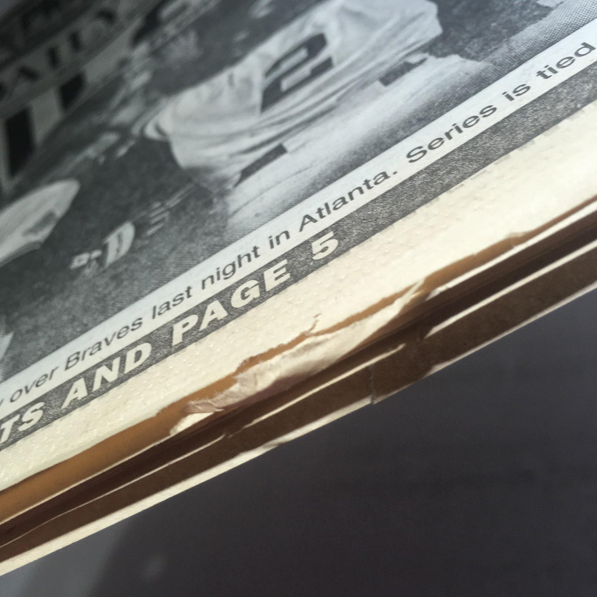 Detail of the NY Daily News showing minor wear and tear, highlighting the edge of the newspaper dated October 24, 1996, with 'All Even' title.