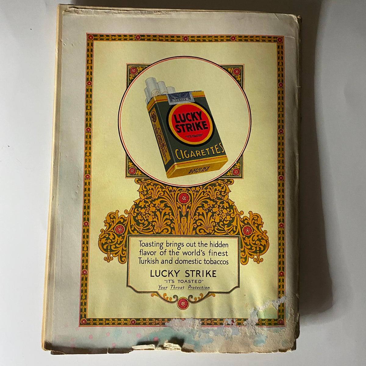 Lucky Strike cigarette advertisement with a decorative design, featured on the back cover of The New Yorker Complete Magazine – April 9, 1927. The ad emphasizes the unique flavor of Turkish and domestic tobaccos.