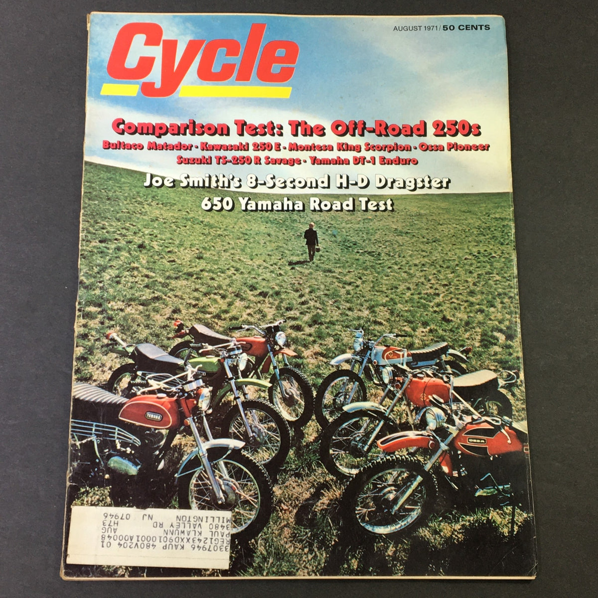Cover of VTG Cycle Magazine August 1971 featuring a comparison test of the Bultaco Matador, Kawasaki 250 E, and Yamaha DT-1, showcasing several motorcycles on a grassy field.