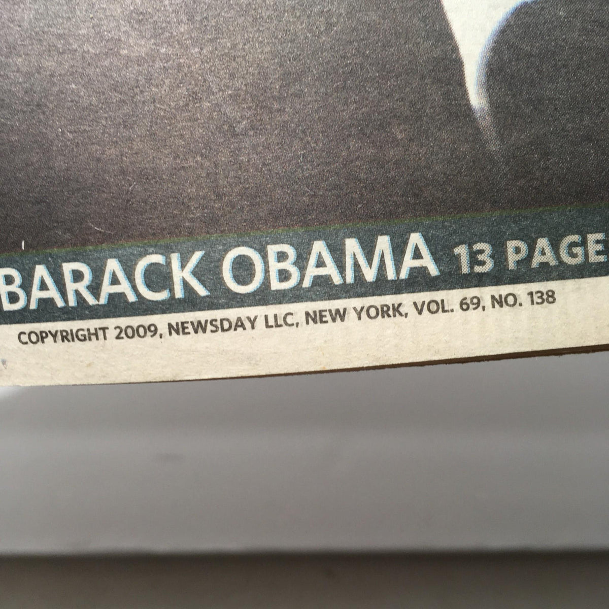 Close-up view of newspaper printing showing 'BARACK OBAMA' and publication details from Newsday, dated Jan 19, 2009.