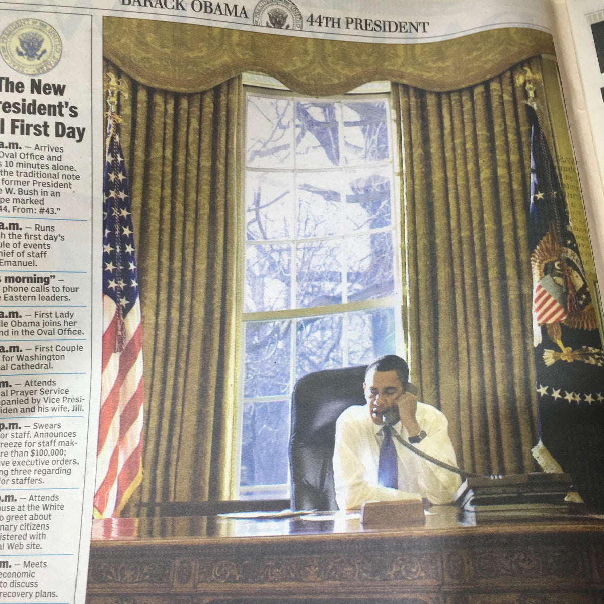 NY Daily News: Jan 22 2009 President Obama Gets To Work - Barack Obama seated in the Oval Office, engaged in a phone call on his first day as President, with U.S. flags and the presidential seal in the background.
