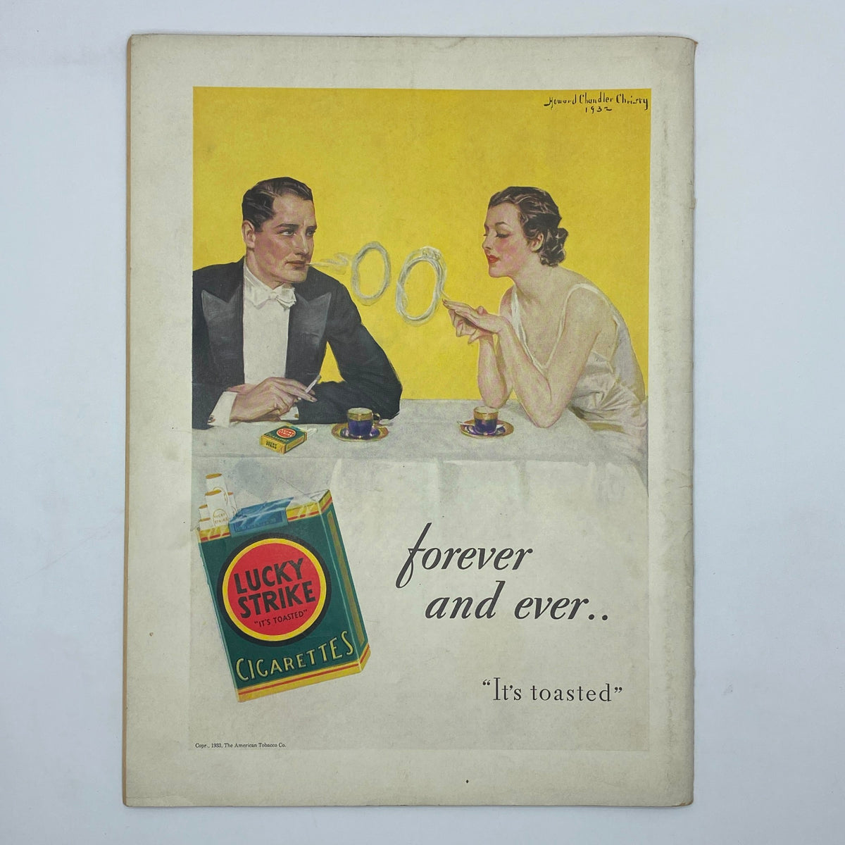 Advertisement for Lucky Strike Cigarettes from The New Yorker Complete Magazine December 31, 1932, featuring a couple at a table with smoke rings and a vibrant yellow background.