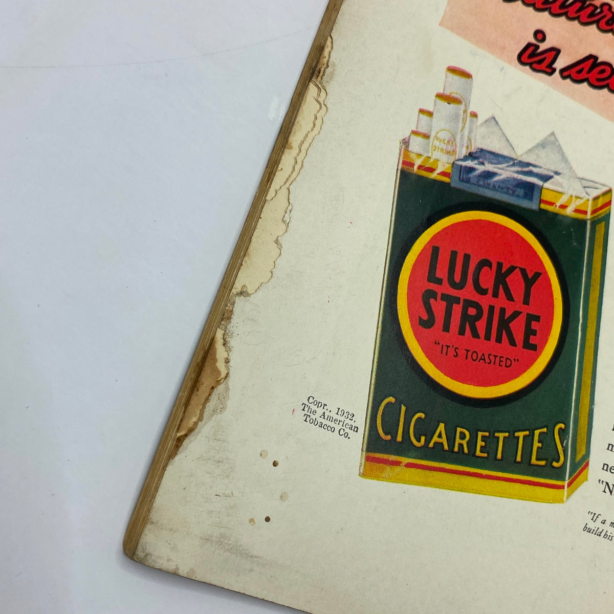 Close-up view of a vintage advertisement for Lucky Strike cigarettes from The New Yorker Complete Magazine, October 22, 1932 featuring Peter Arno's cover. The image highlights details such as the worn edges of the magazine, showcasing its collectible condition.