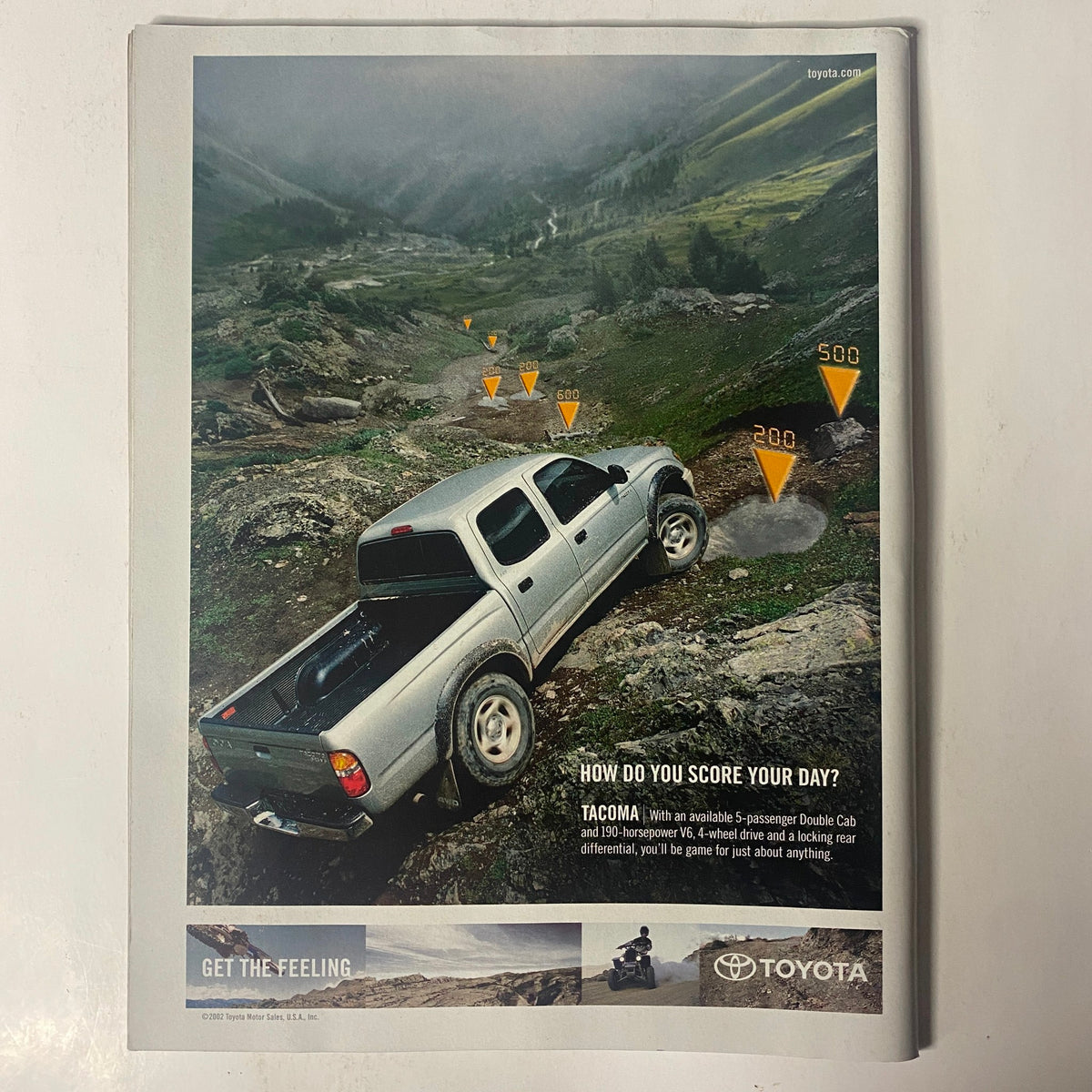 Back cover of Sports Illustrated Magazine July 14, 2003 displaying a Toyota advertisement with a Tacoma truck navigating through rugged terrain.