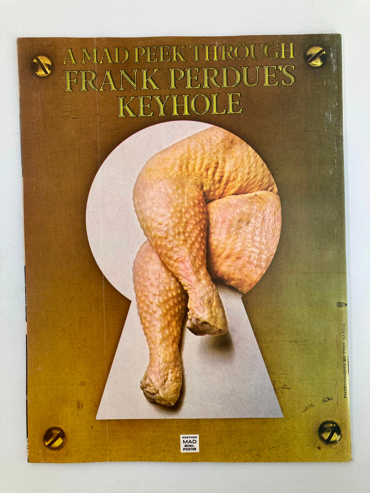 Back cover of Mad Magazine January 1976 No. 180, showcasing a humorous image titled 'A Mad Peek Through Frank Perdue's Keyhole.' Vintage design exemplifying the magazine's comedic style.