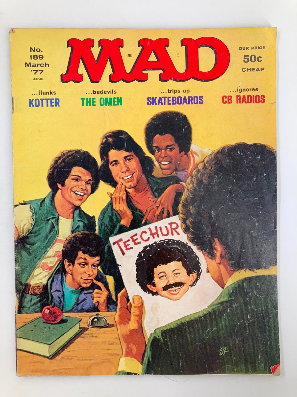 Mad Magazine March 1977 No. 189 featuring John Travolta on the cover, showcasing a colorful illustration of a group of teenagers, humorously interacting around a character holding a drawing titled 'TEACHER'. Vintage collectible magazine from the 1970s.