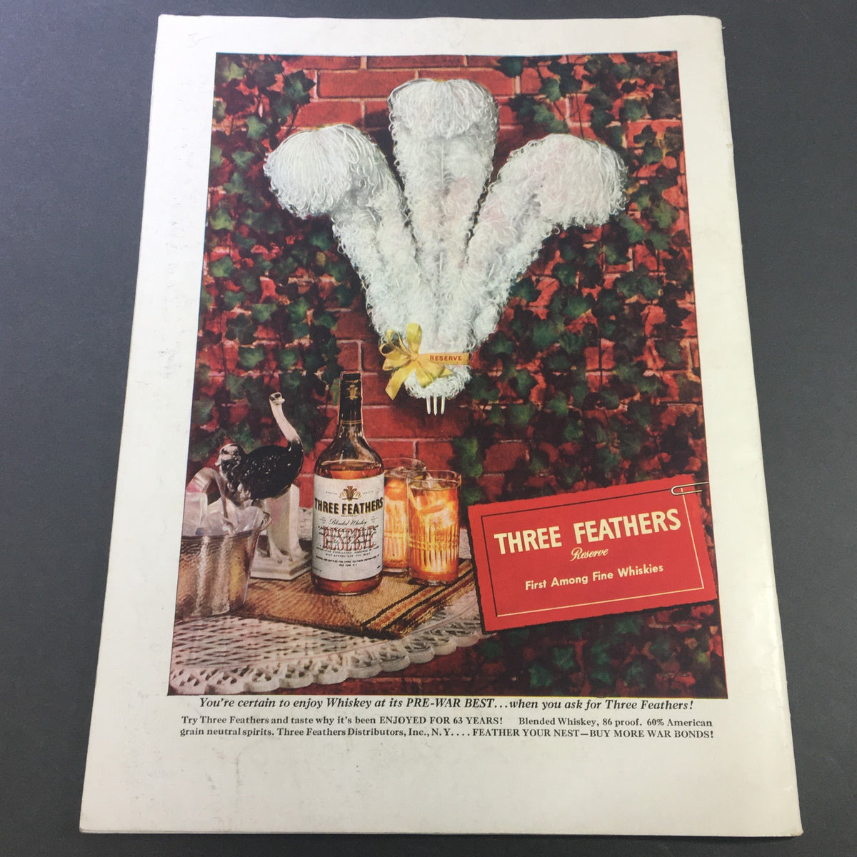 Cover of VTG Gourmet Magazine - August 1945 featuring an advertisement for Three Feathers Whiskey with a decorative background showcasing fine spirits and a festive setting.