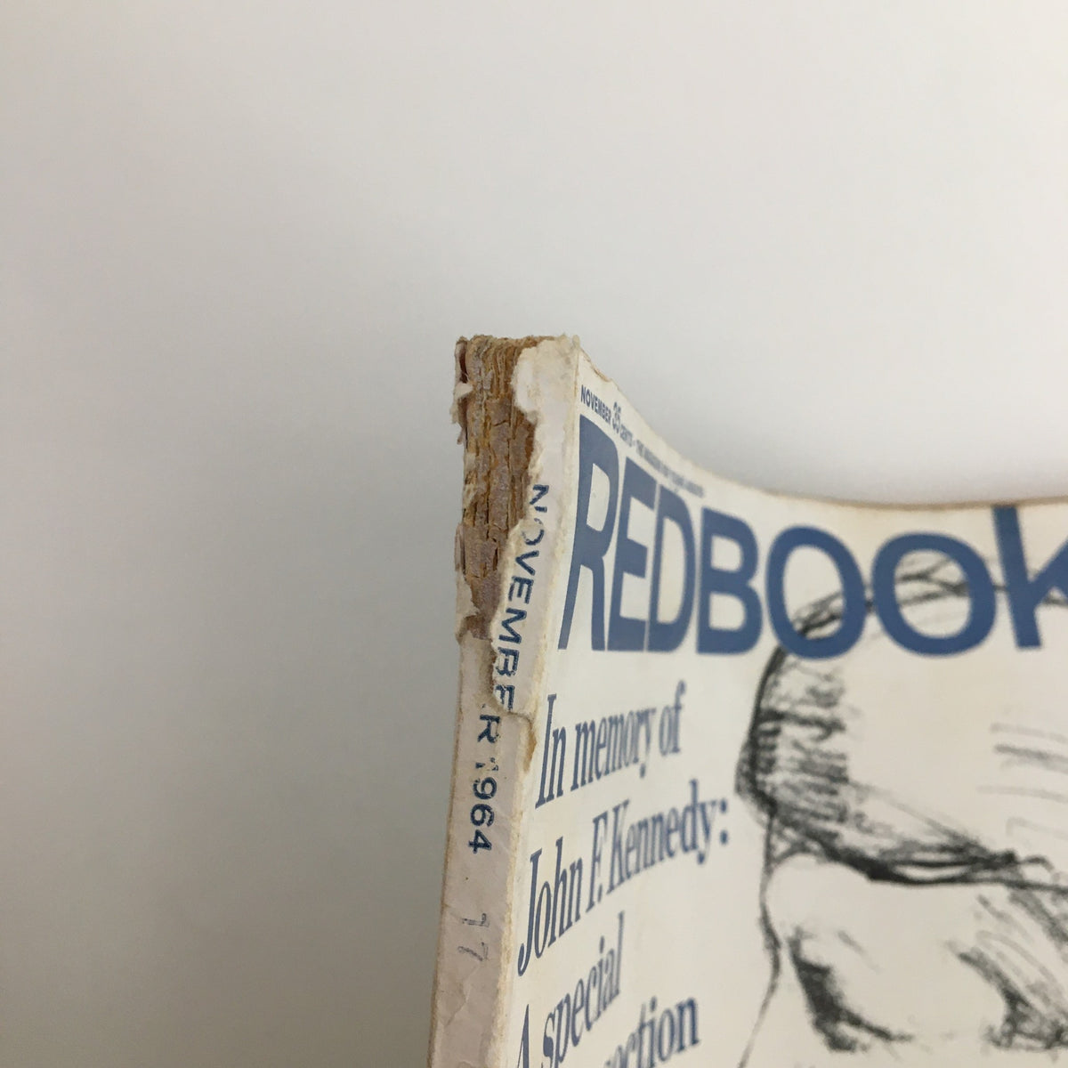 Close-up of the side view of Redbook Magazine November 1964 showcasing minor wear and the publication date.