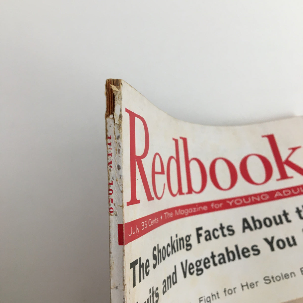 Close-up view of the top corner of the Redbook Magazine July 1958 Cover Photograph of Kathy Crosby, highlighting the magazine's vintage appeal with minor wear.