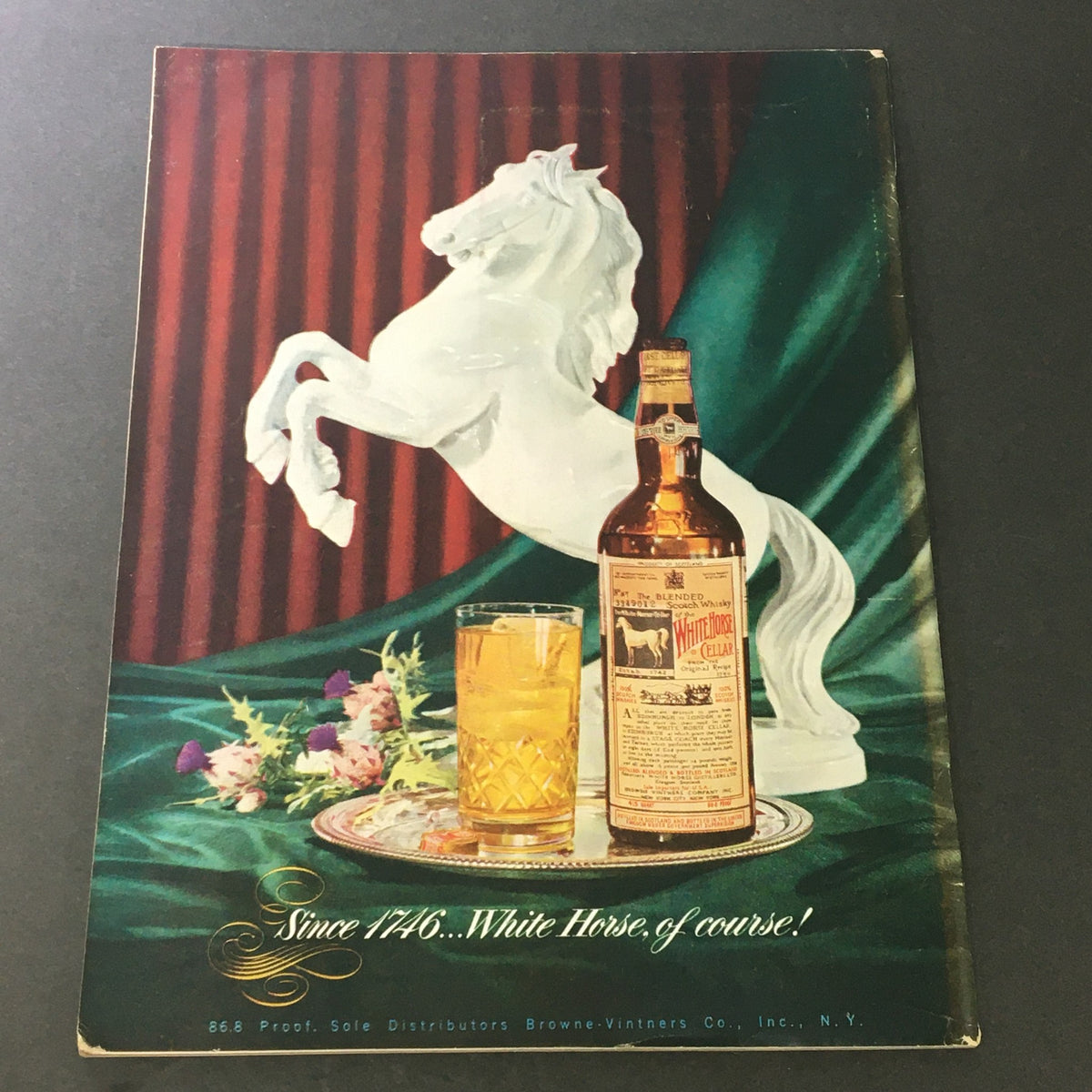 Vintage advertisement from VTG Gourmet The Magazine of Good Living November 1951 showcasing a whiskey bottle beside a decorative white horse figure.