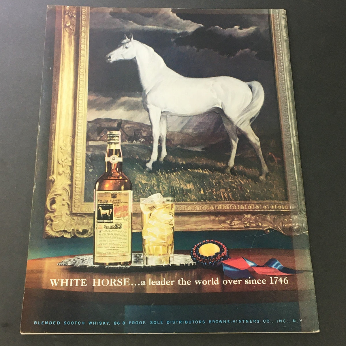 VTG Gourmet: The Magazine of Good Living September 1952 back cover showcasing an artistic depiction of a white horse alongside a whiskey bottle in front of an elaborate framed painting, enhancing vintage aesthetic.