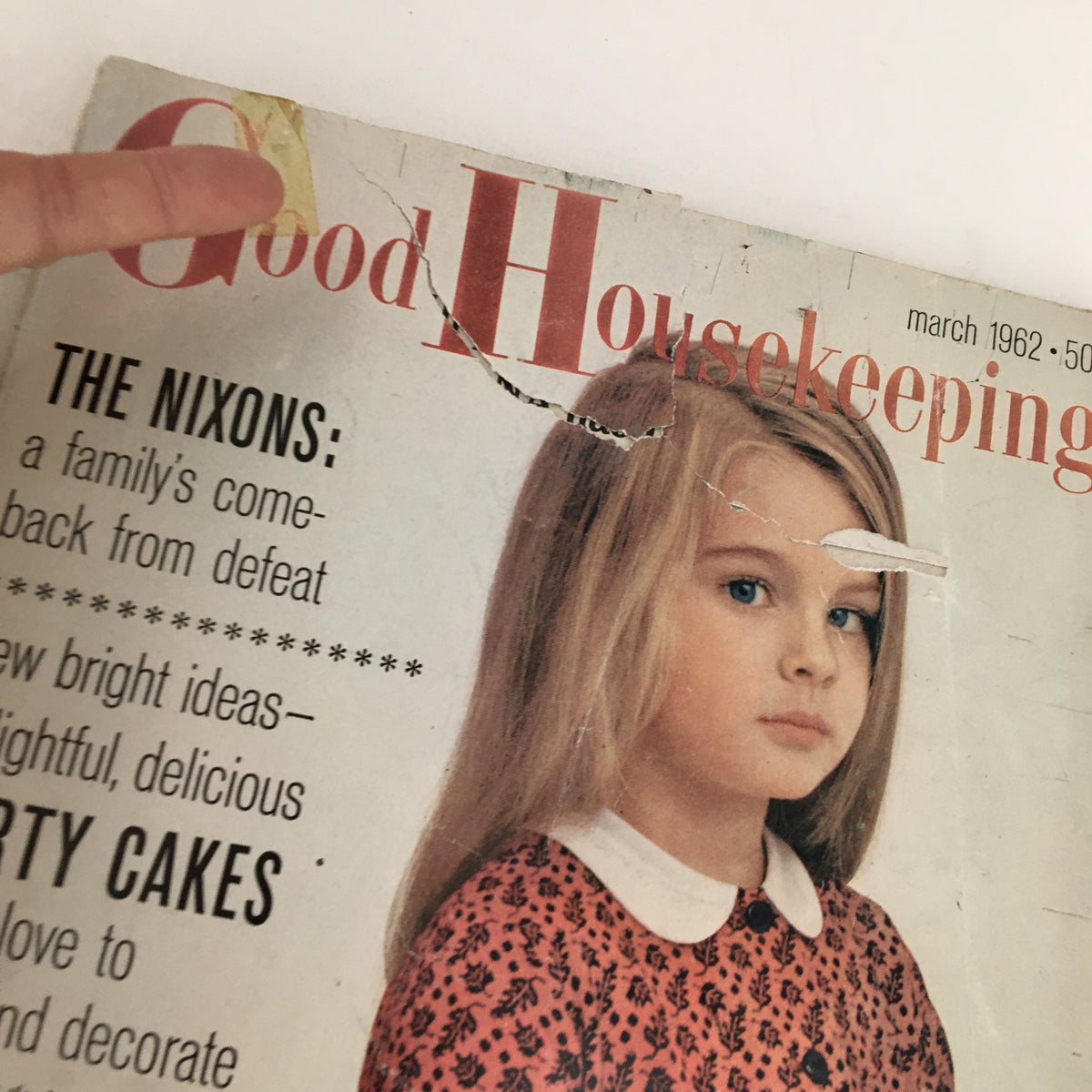 Cover of Good Housekeeping Magazine March 1962 featuring a young girl and the headline 'The Nixons: a family’s comeback from defeat.' Condition shows wear with visible rips and a torn edge.