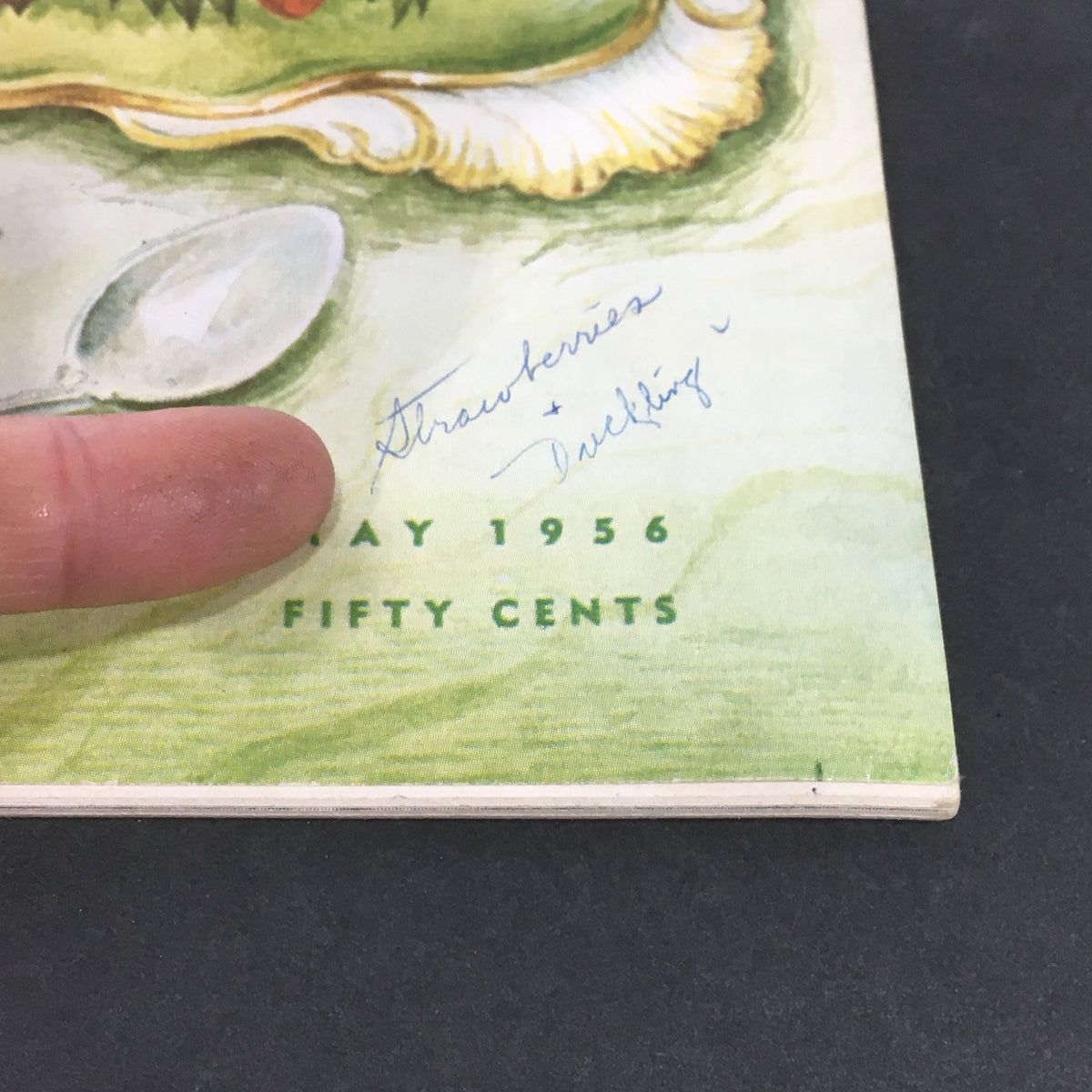 Bottom section of VTG Gourmet The Magazine of Good Living May 1956 cover, displaying text about strawberries and duckling, with a vintage design.