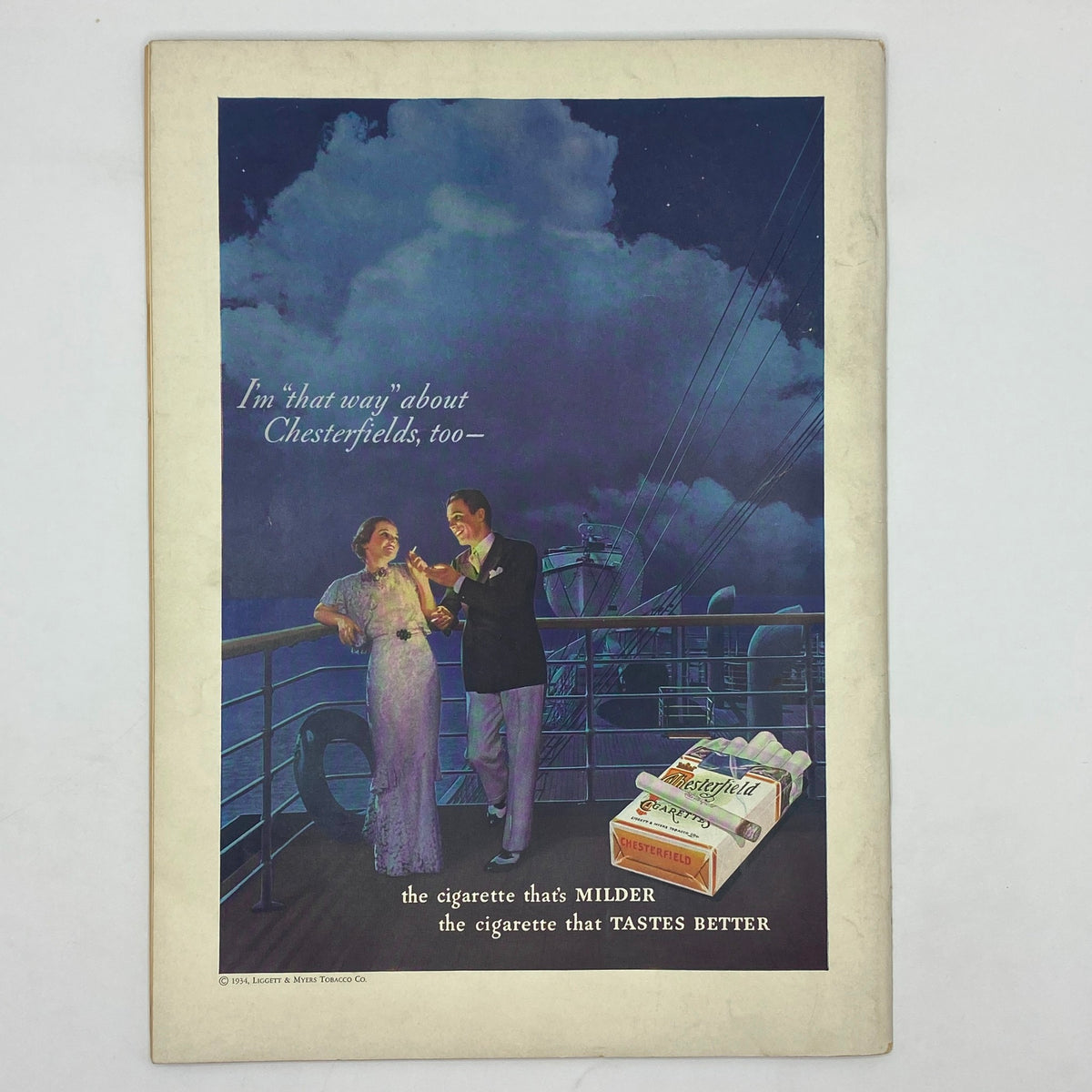Vintage advertisement from The New Yorker Complete Magazine July 7, 1934, featuring a couple on a boat enjoying Chesterfield cigarettes, capturing the essence of 1930s advertising culture.