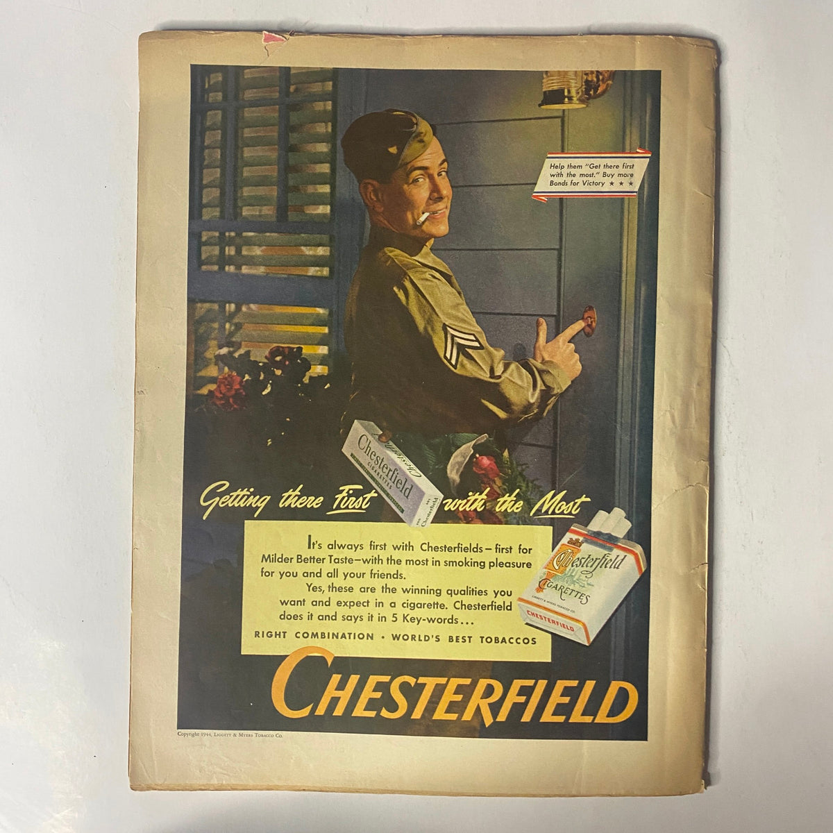 Vintage advertisement from Radio Mirror Magazine July 1944 titled 'Getting There First with the Most,' showcasing a World War II soldier promoting Chesterfield cigarettes. Ideal for collectors of historical magazines and wartime memorabilia.