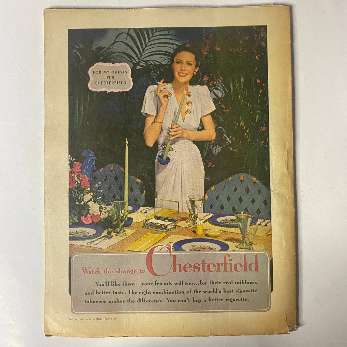 Back cover of Radio Mirror Magazine May 1944 promoting Chesterfield cigarettes, illustrating vintage advertising style with a woman and elegant table setting.