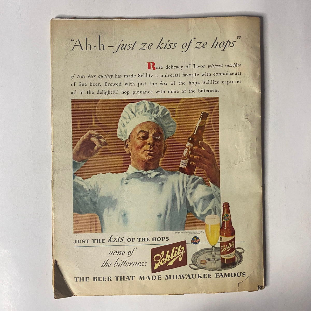 Vintage advertisement for Schlitz beer from April 1944, showcasing a cheerful chef promoting the drink with the tagline 'Just the kiss of the hops - none of the bitterness.'