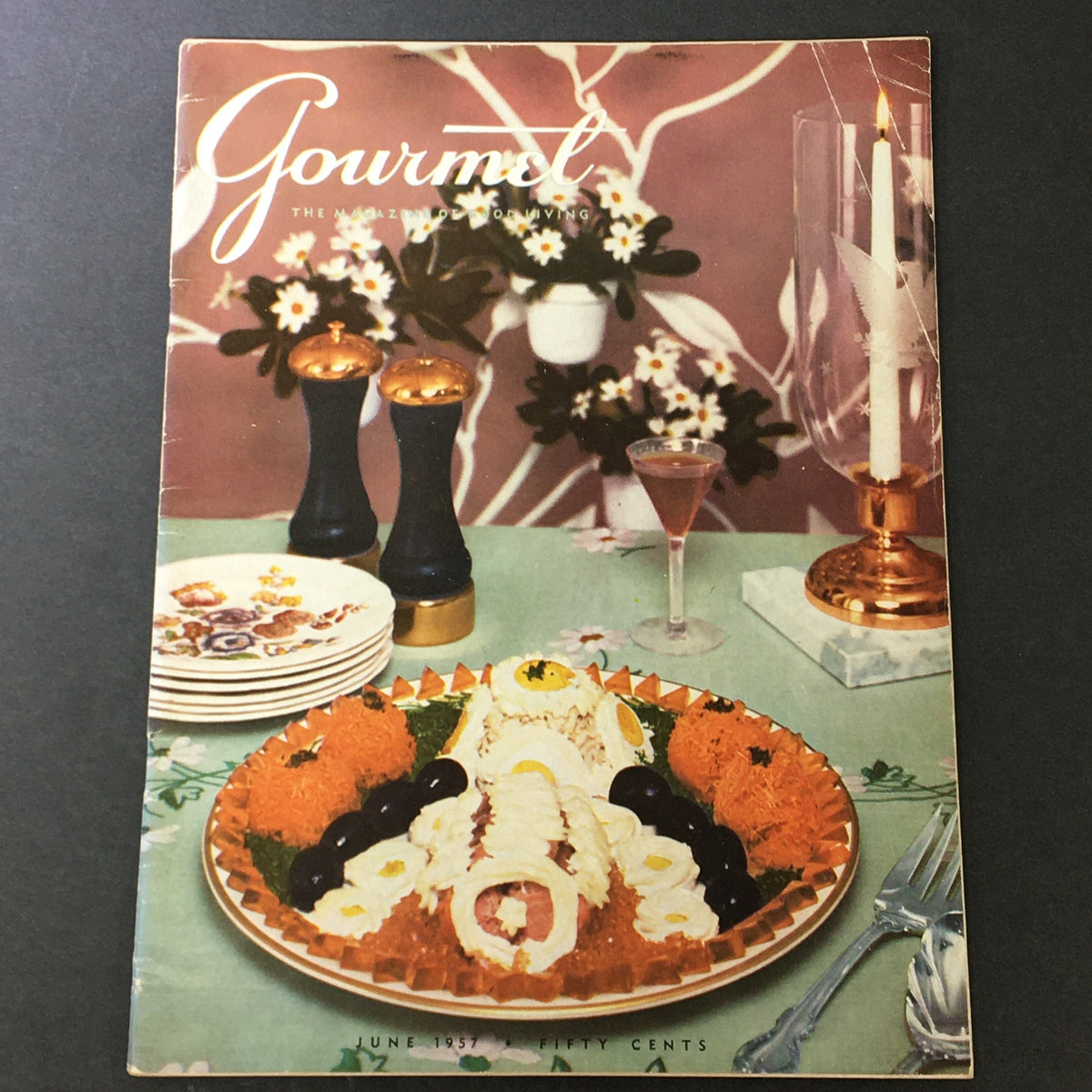 Cover of VTG Gourmet The Magazine of Good Living June 1957, featuring an elegant dining table set with a colorful dish and decorative elements.