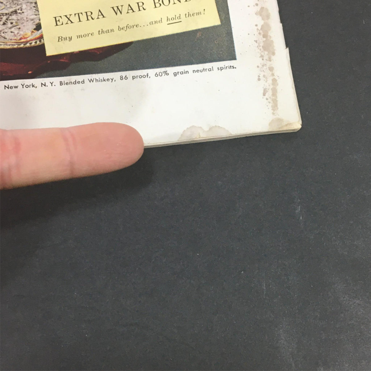 Detailed shot highlighting an advertisement from the September 1944 issue of VTG Gourmet: The Magazine of Good Living, promoting Extra War Bonds alongside a classic whisky drink.