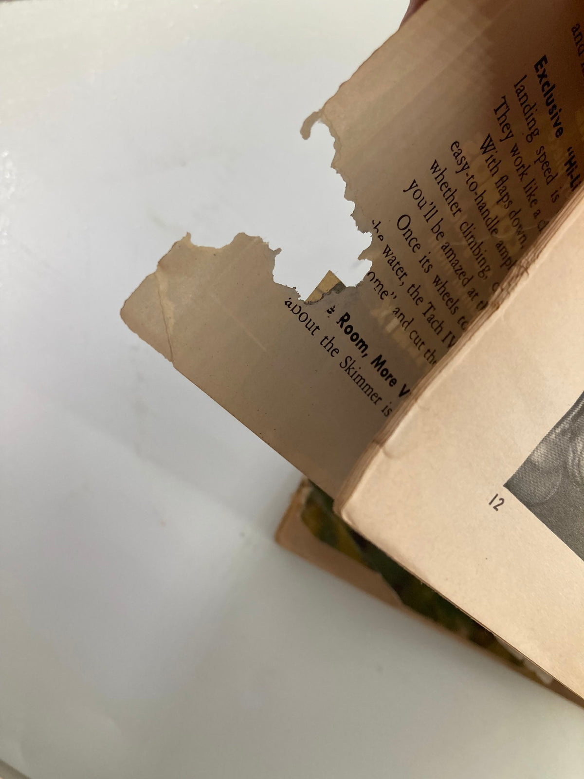 Interior page of VTG Flying Magazine March 1958, showcasing the vintage paper quality with a significant tear, reflecting the magazine's history.