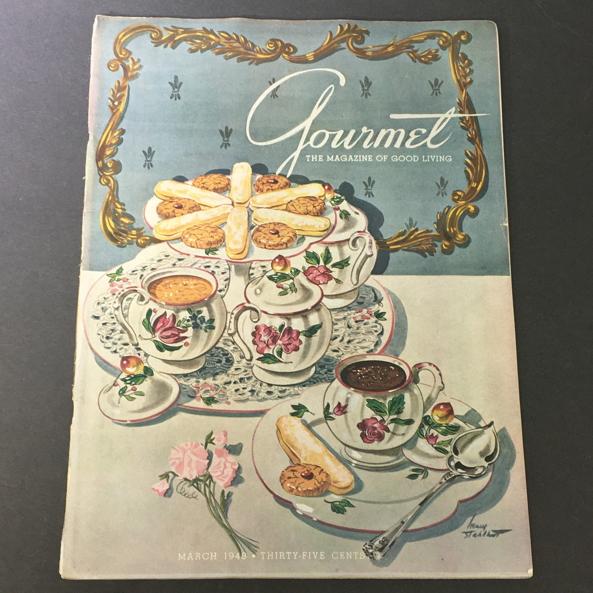 Cover of the March 1948 issue of VTG Gourmet: The Magazine of Good Living featuring an elegantly arranged tea set with pastries and floral accents.