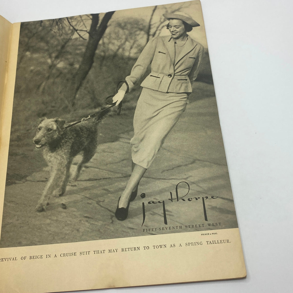 Vintage advertisement layout in The New Yorker magazine from December 28, 1935, showcasing a woman in a stylish outfit walking a dog, highlighting a revival of beice fashion.