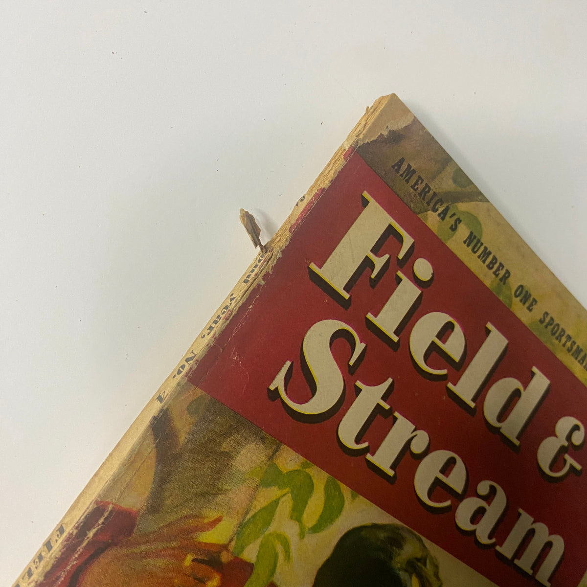 Close-up view of the top corner of the Field & Stream Magazine August 1947, showing wear and damage, emphasizing its vintage condition.
