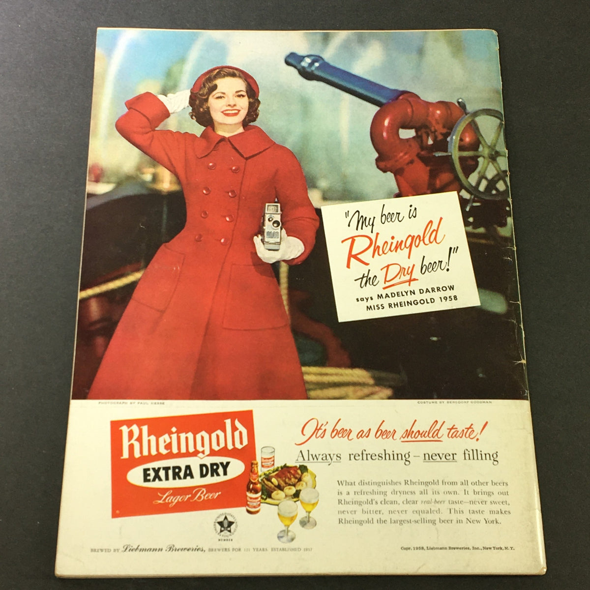Back cover advertisement of VTG Gourmet The Magazine of Good Living March 1958, showcasing a vintage Rheingold beer ad with a model in a red coat.