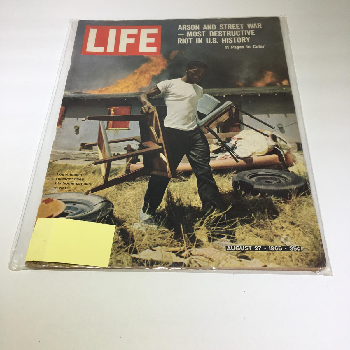 Life Magazine cover from August 27, 1965, featuring a dramatic scene of a resident fleeing his home amid chaos, highlighting the themes of arson and street war as the magazine covers significant societal issues of the time. This issue is in good condition and captures pivotal moments in U.S. history.