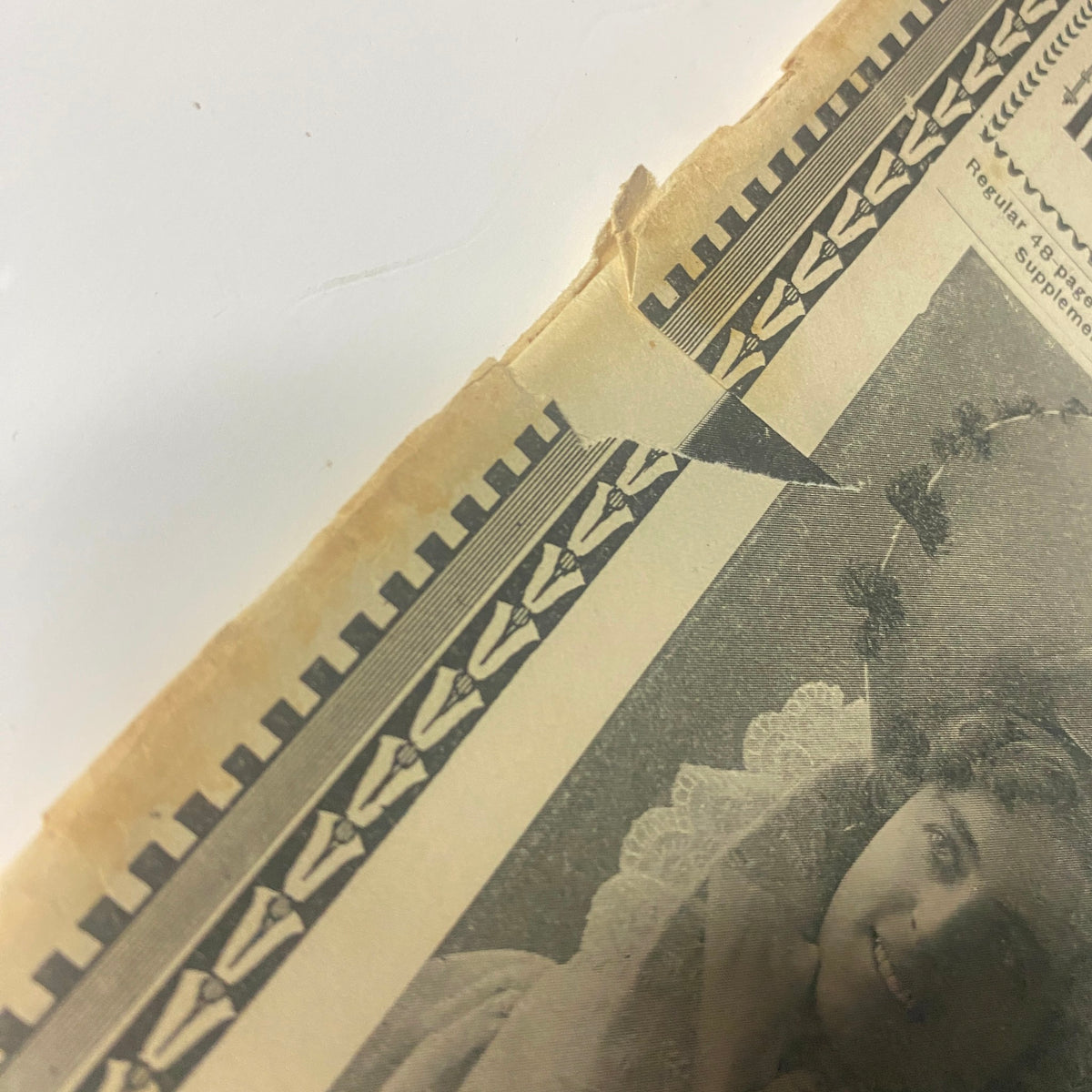 Close-up view of the cover of The New England Home Magazine, May 21, 1899, showing a tear on the edge and highlighting the vintage design, featuring the phrase 'Spring Has Come' with a woman's portrait.
