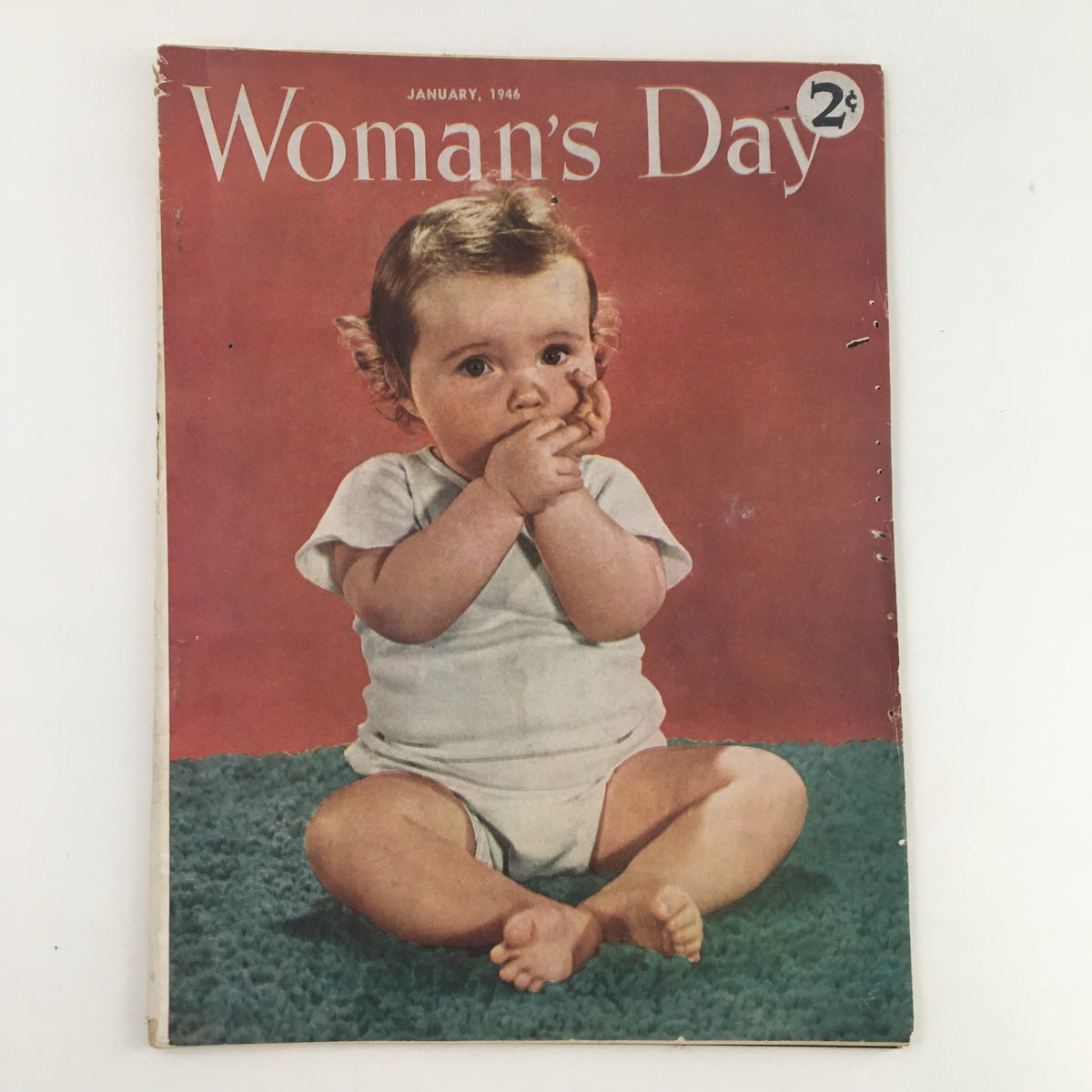 Woman's Day Magazine January 1946 featuring a vintage cover with a baby sitting on a green carpet, showcasing nostalgic 1940s aesthetics.