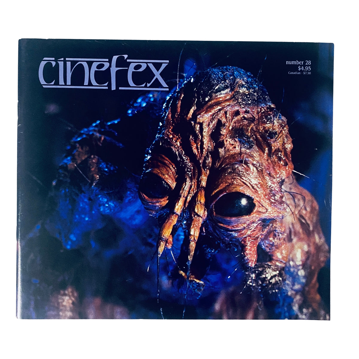 Cover of Cinefex Magazine November 1986 No. 28 featuring a detailed close-up of the doomed creature from The Fly, showcasing its intricate design and colors.