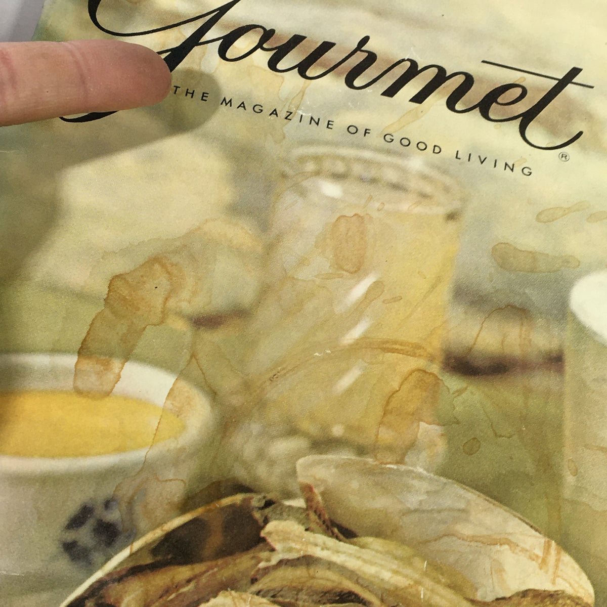 Close-up of the cover of VTG Gourmet The Magazine of Good Living June 1963, highlighting the title and details of vintage dining, with stains that add to its nostalgic charm.