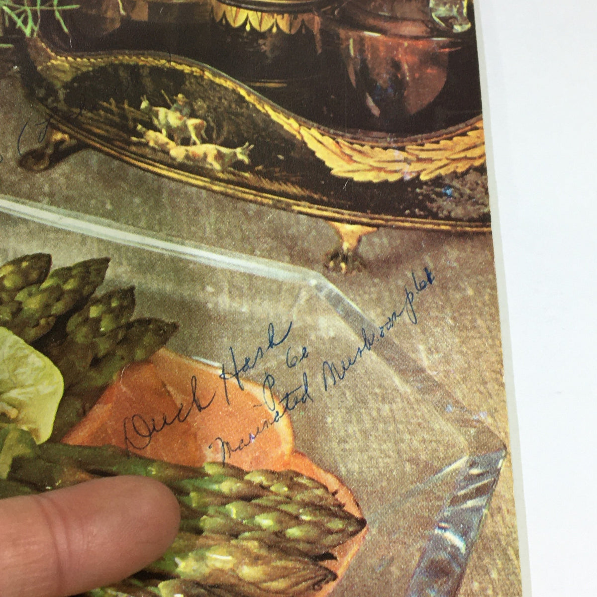 Detailed view from VTG Gourmet The Magazine of Good Living April 1963 capturing handwritten culinary notes next to a decorated glass serving platter, highlighting the personal touch of this vintage magazine.