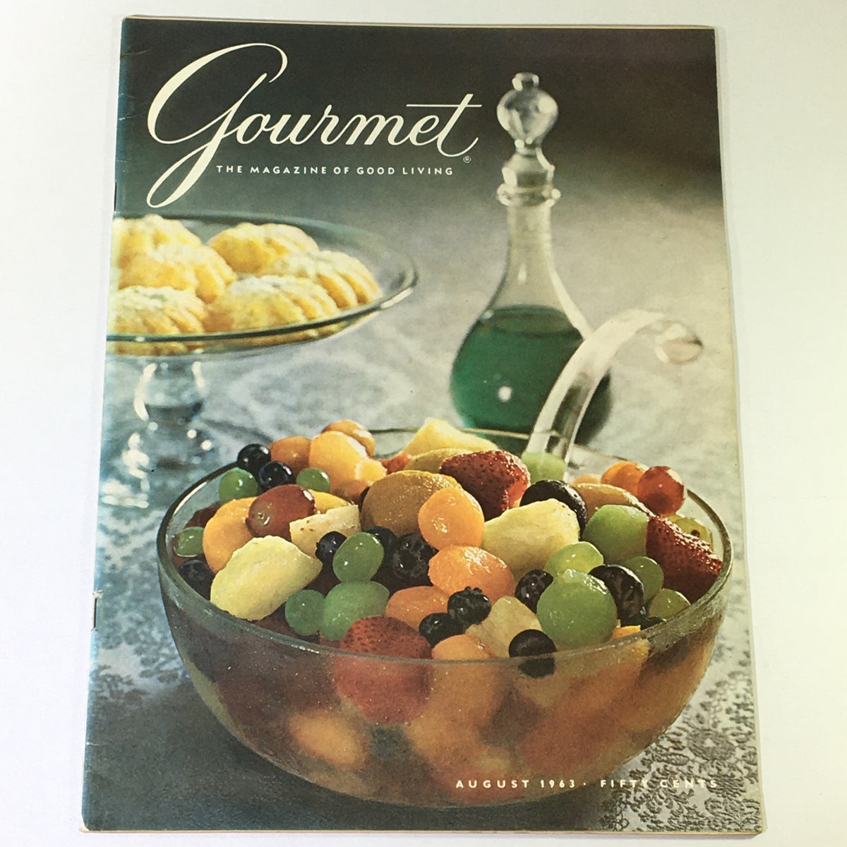 Cover of VTG Gourmet The Magazine of Good Living August 1963 featuring a vibrant fruit salad in a glass bowl with assorted fruits, evoking a nostalgic culinary culture.