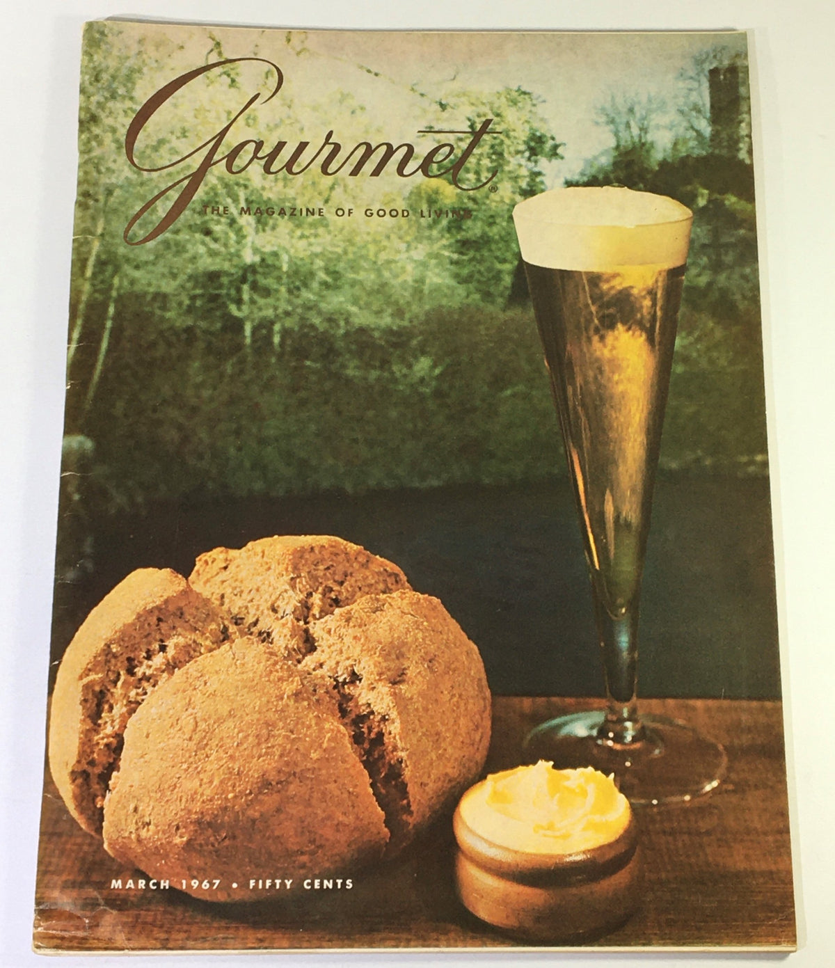 Cover of VTG Gourmet The Magazine of Good Living March 1967 showing a glass of beverage, bread, and butter on a wooden surface.