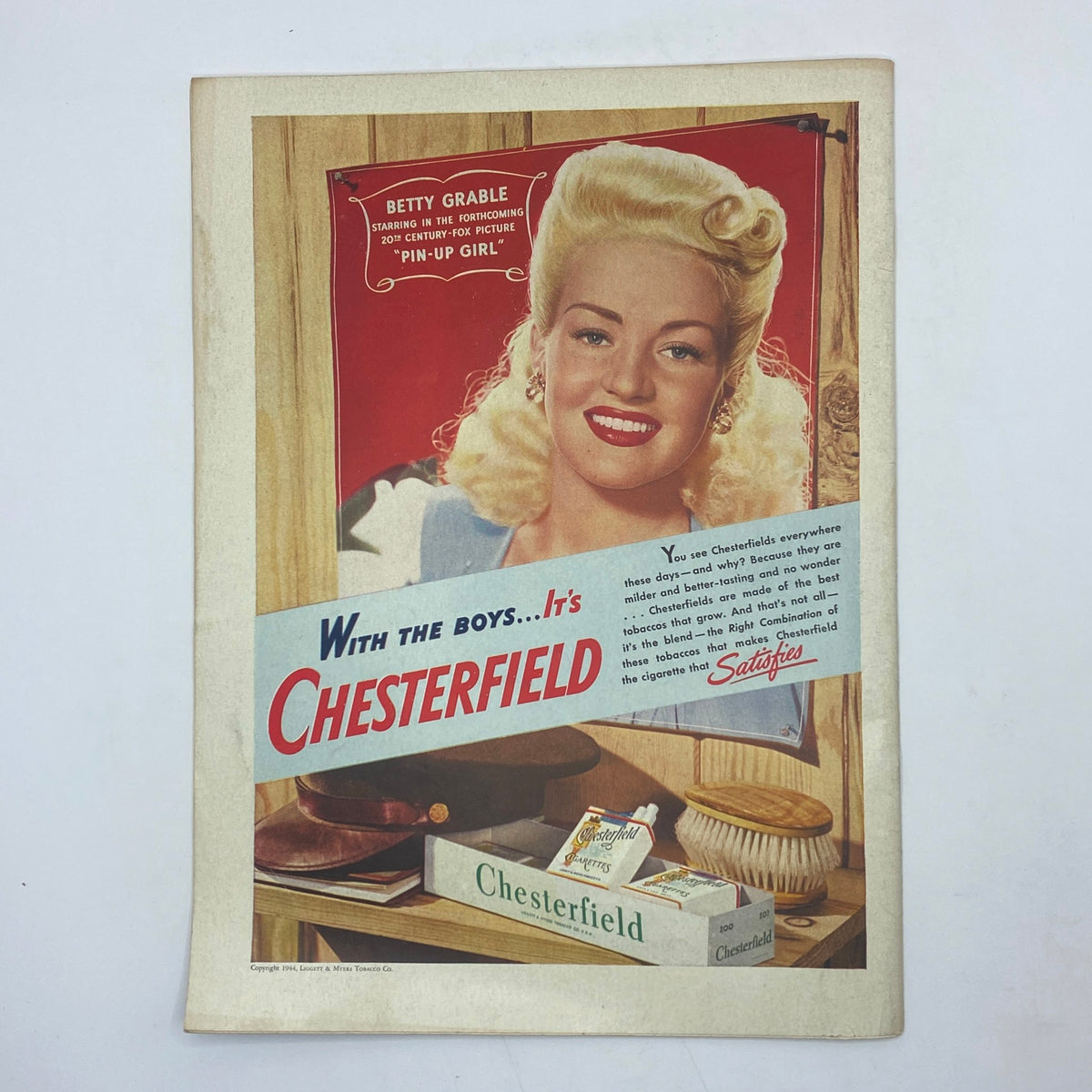 Vintage advertisement in The New Yorker January 8, 1944, showcasing Betty Grable promoting Chesterfield cigarettes with a glamorous image.