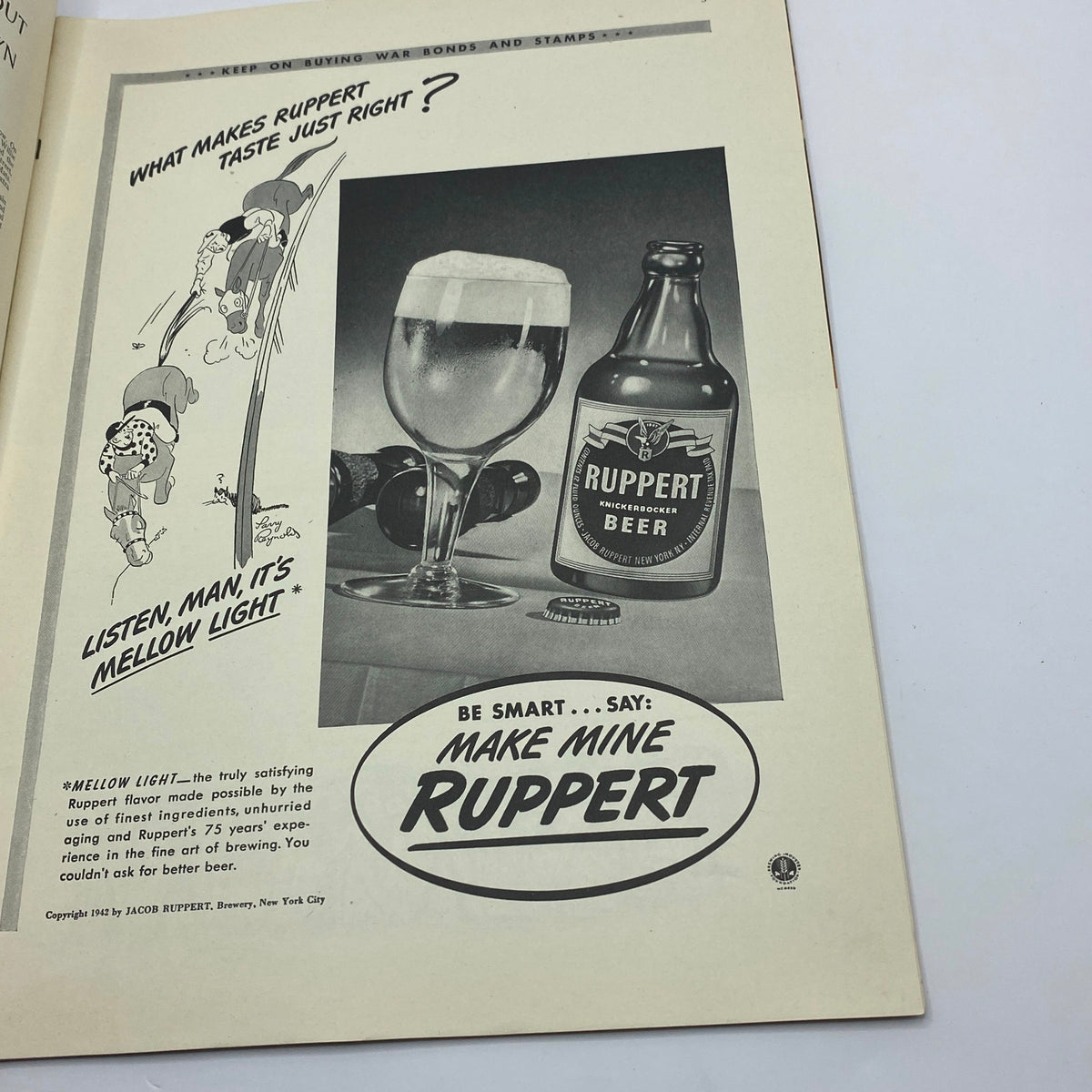 Ruppert Beer advertisement featuring a frothy beer in a glass and a bottle of Ruppert, with a humorous illustration, from The New Yorker Complete Magazine July 4, 1942.