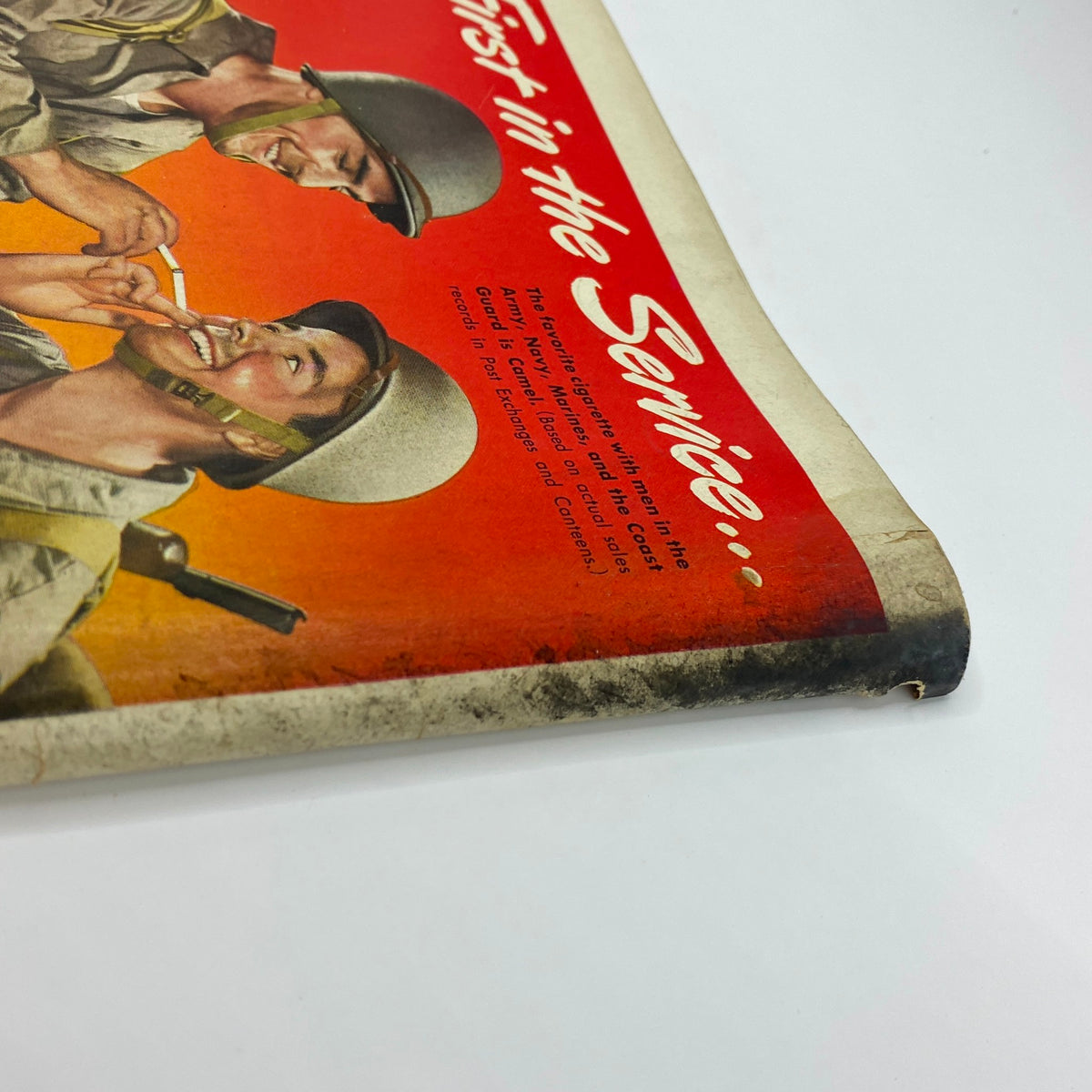 Side angle of a vintage advertisement in The New Yorker Complete Magazine June 5, 1943 for Camels cigarettes, featuring soldiers and the slogan 'First in the Service...' with noticeable wear and nostalgia from the World War II era.